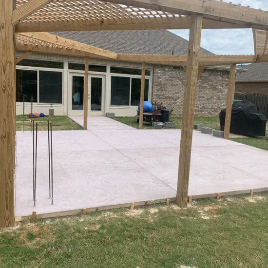 Concrete slab poured beneath a wood pergola at a North Alabama home