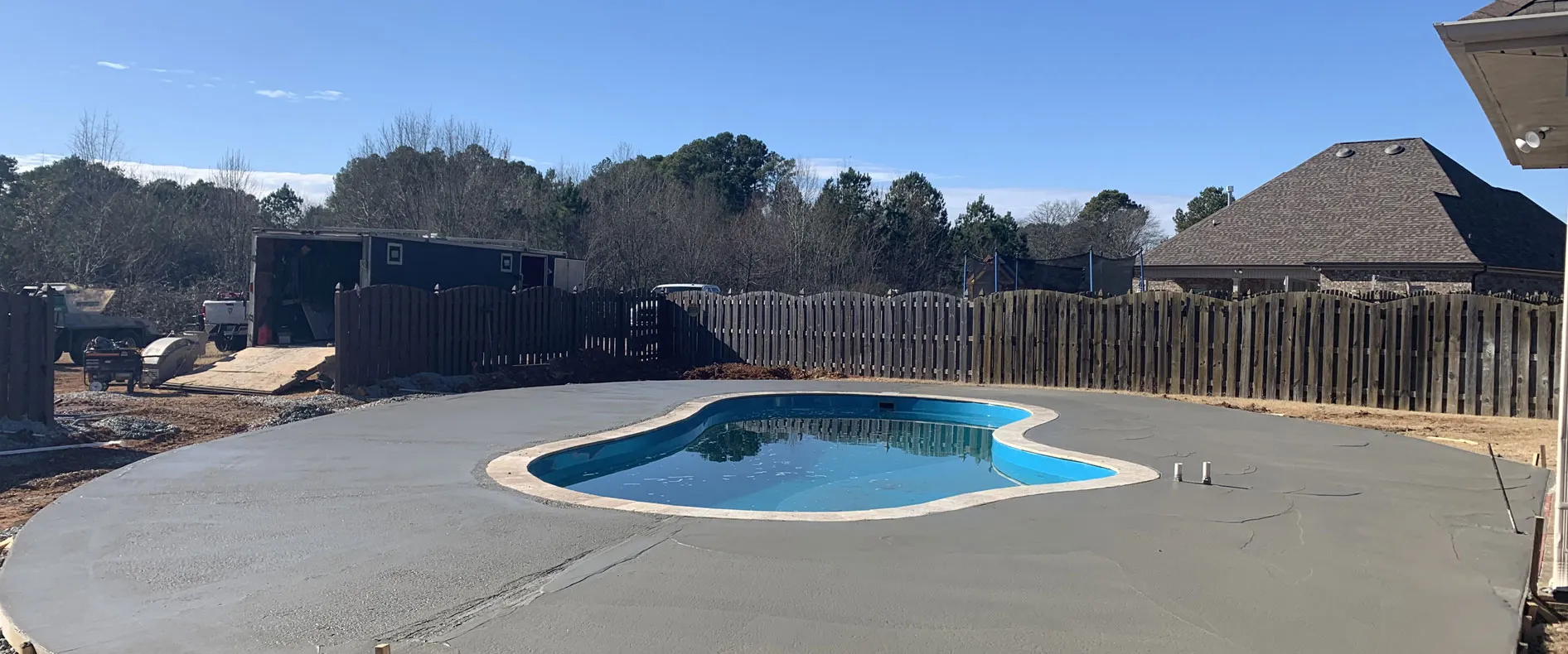Concrete pool deck poured around a backyard swimming pool in Huntsville, AL